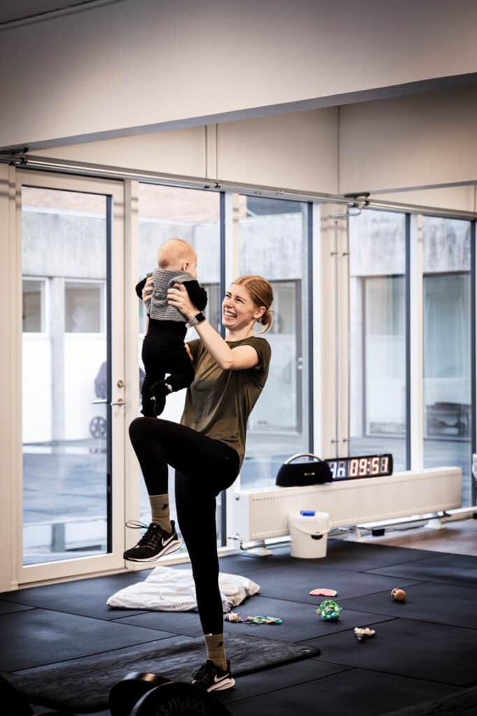 Mor træner med sin baby på barselshold